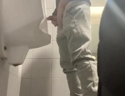 2 Boys in Sneakers Having Fun at Public Toilets' Urinal
