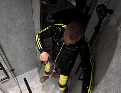 Rubber Man Pisses with Uncut Cock